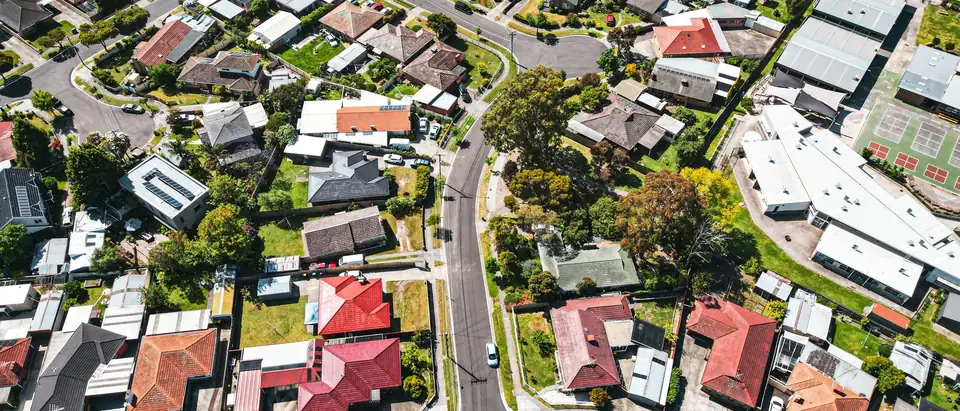 An aerial view of suburban houses, gardens and curving streets