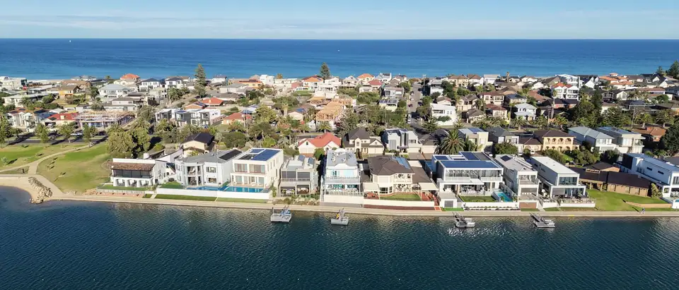 An aerial view of waterside houses with the sea beyond
